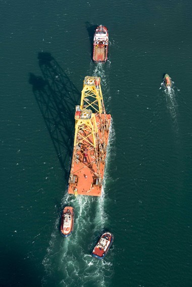 Tugs towing  parts of a wind turbine.