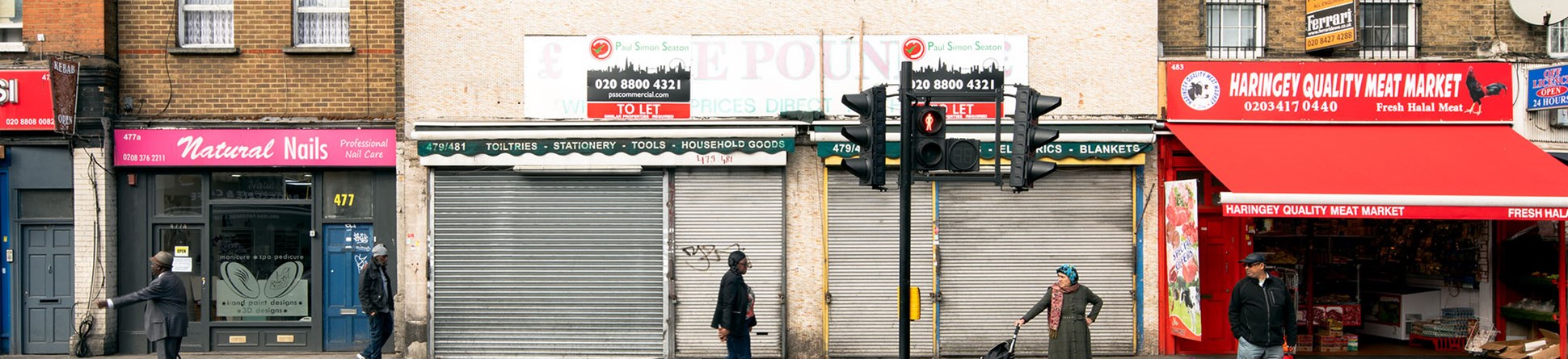 People walking passed derelict shop on high street