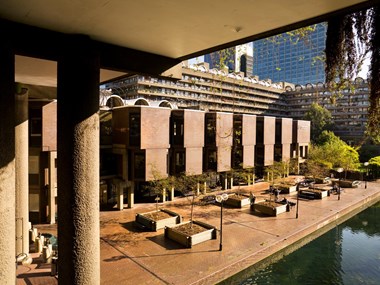 Colour photo showing the Guildhall School of Music and Drama. Sand colour columns extend on the left side in the foreground, with the complex itself in the background.