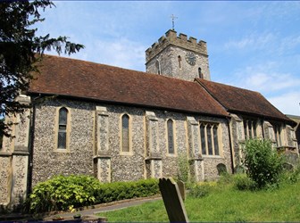 Church and tower with graveyard and some gravestones in the foreground.