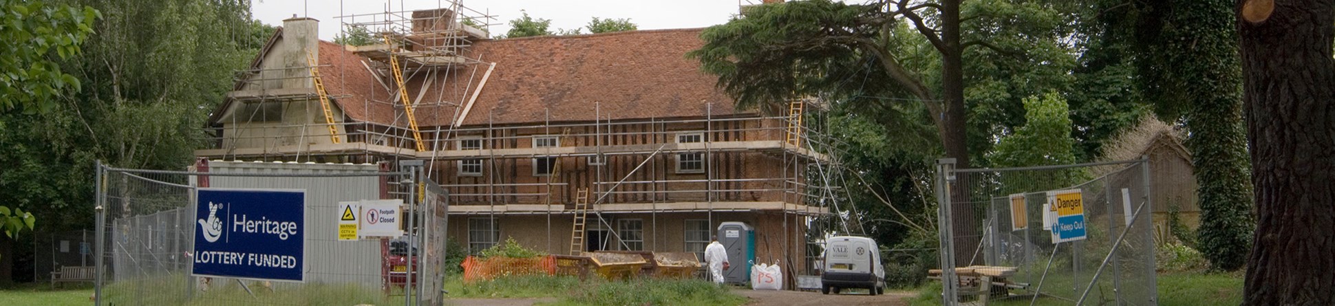 A building covered in scaffolding and a Heritage Lottery Funded sign on a temporary fence.