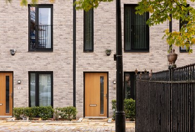 Detail of the ground floor of a modern terraced building faced with brick.