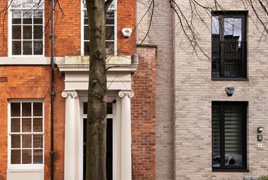 Details of the ground floor of a historic Georgian building adjacent to a modern brick clad terrace.