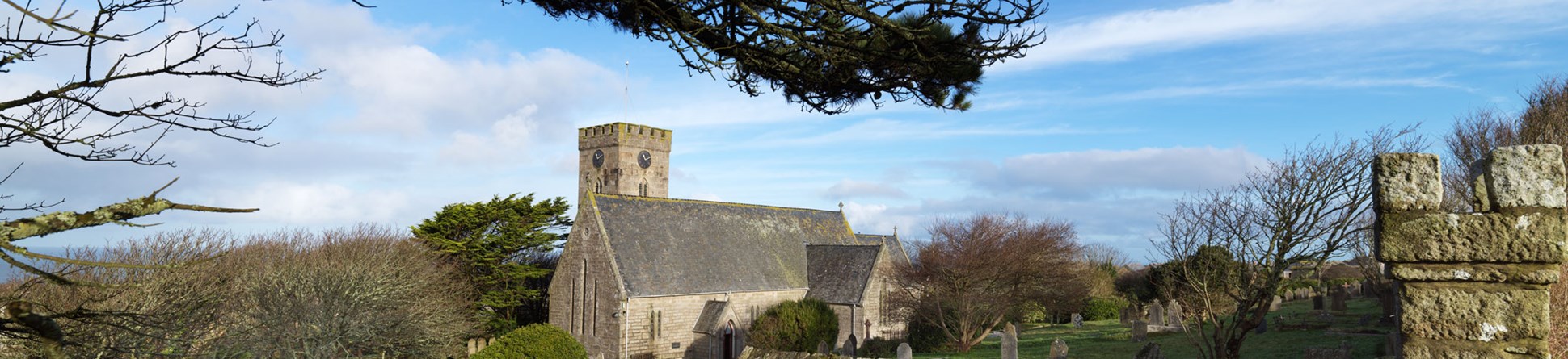 A stone-built church with a boundary wall in the foreground.