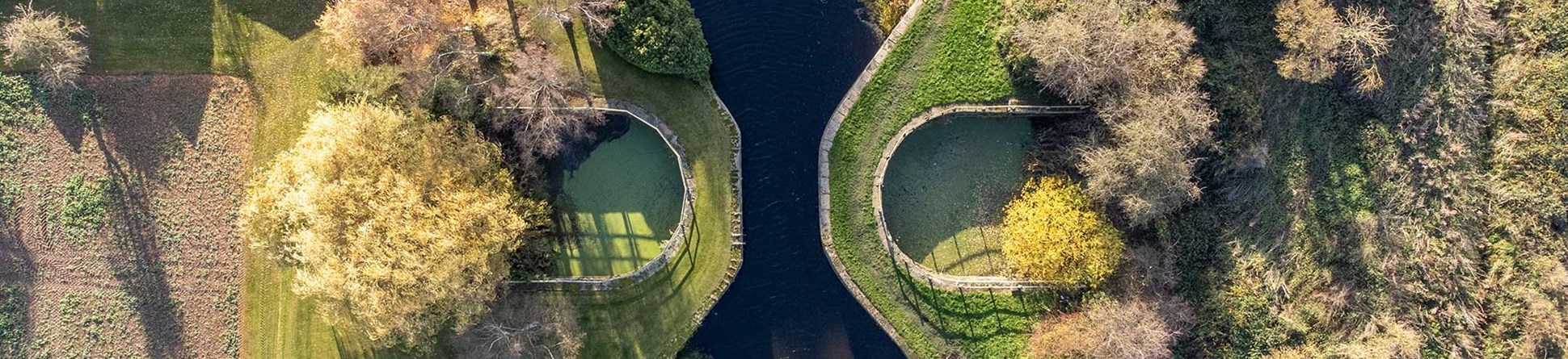 A pair of roughly D-shaped collection ponds either side of the canal channel