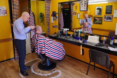 A man getting his hair cut in a barber shop.