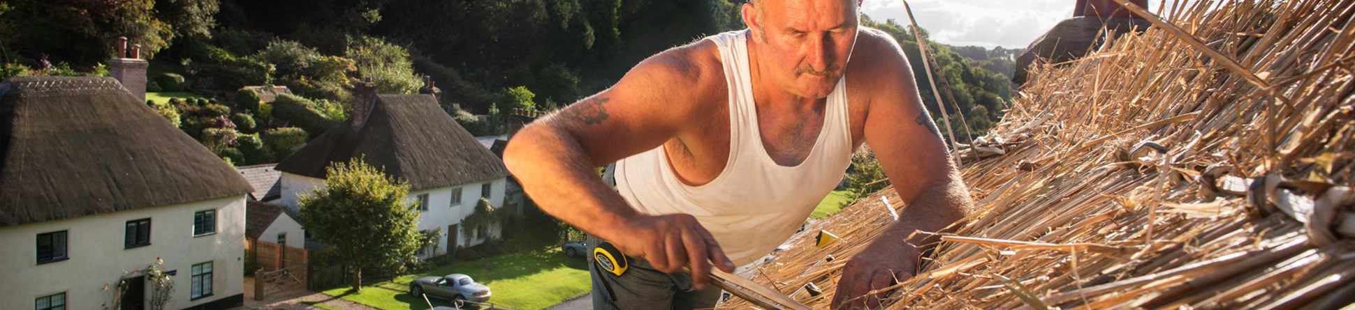 A thatcher working on a roof.