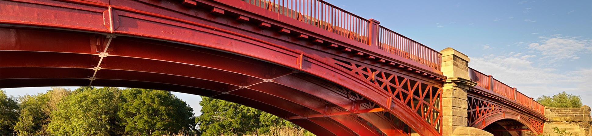 General view of a cast iron and rusticated ashlar three segmental arched bridge. 