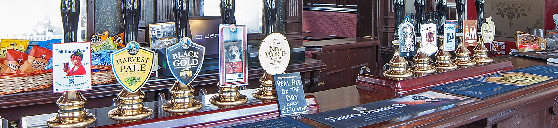 A row of hand pumps on a pub bar at the Woodman pub Birmingham