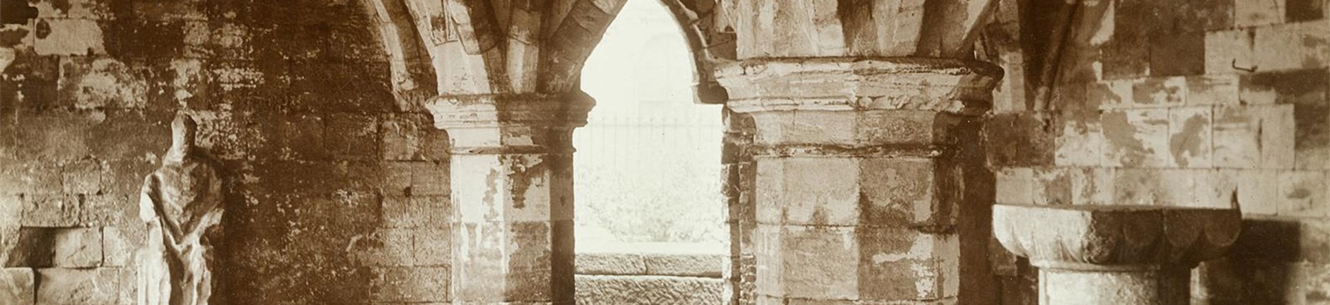 A view of the undercroft of St Leonard's Hospital, York with a statue of a seated figure adjacent to the wall