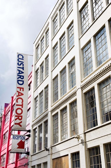 White painted factory building with signs reading: 
CUSTARD FACTORY 
RECEPTION