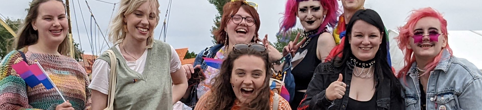 A colourful of people pose for the camera in a festival field