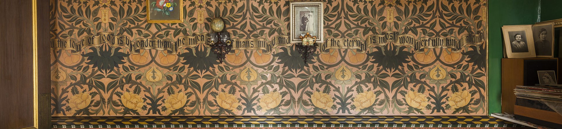 The intricate green and gold design of a wall in the drawing room at artisan decorator David Parr's House in Cambridge