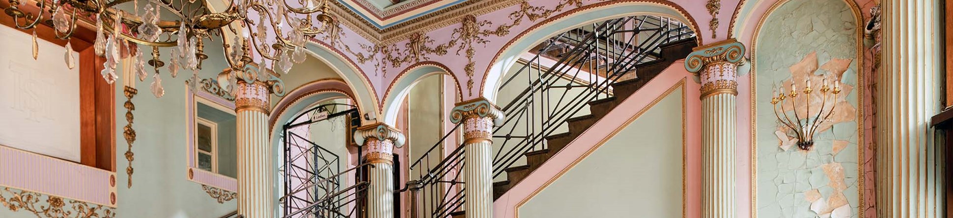 View of the Streatham Hill Theatre foyer with decorated walls, ceiling and chandelier