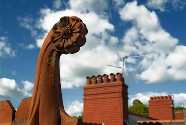 Victorian roof finial viewed against a blue sky.