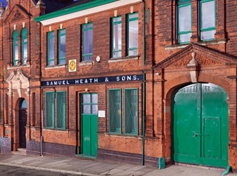 General view of Samuel Heath and Sons red brick office building showing Jacobean influences and green ornamentation.