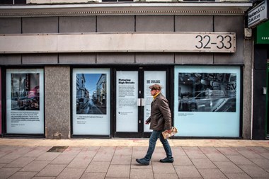 A man walking passed window installations